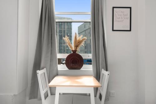 uma mesa e duas cadeiras em frente a uma janela em Studio 2- Archway Station em Londres