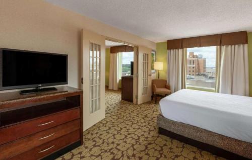 a hotel room with a bed and a flat screen tv at Hilton Garden Inn Pittsburgh University Place in Pittsburgh