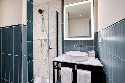 a bathroom with a sink and a shower at Citadines Canal Amsterdam in Amsterdam