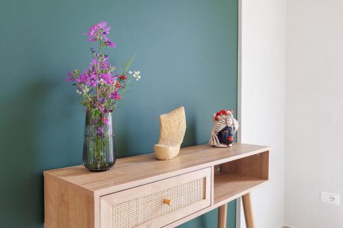a table with a vase of flowers on it at Malva Rooms in Agrigento