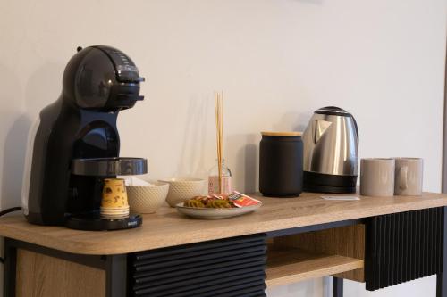a table with a coffee maker and a plate of food at Malva Rooms in Agrigento