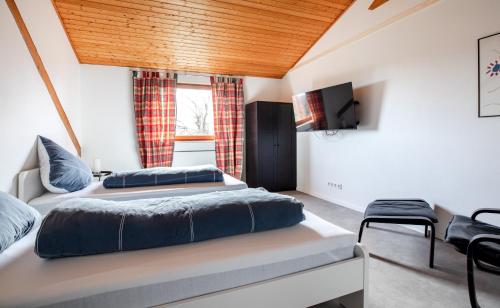 a bedroom with two beds and a flat screen tv at Ferienwohnung Wäller Fernblick in Westerburg