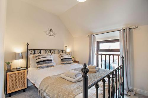 a bedroom with a bed with pillows and a window at Goldfinch cottage in Newton