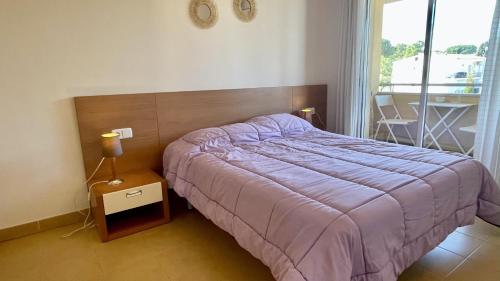 a bedroom with a bed with a purple blanket at Riells Blau C302 in L'Escala