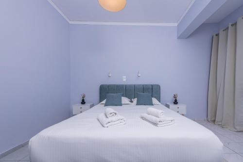 a bedroom with a large white bed with towels on it at GIN Wellness Hotel in Pirgos