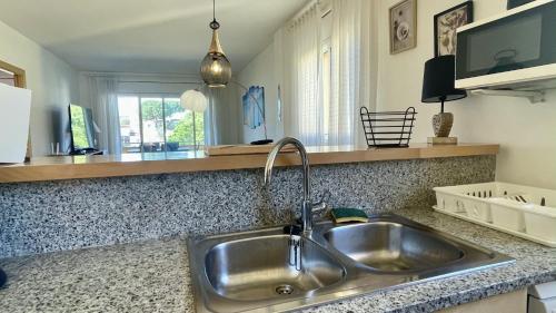a kitchen with a stainless steel sink in a kitchen at Riells Blau C302 in L'Escala
