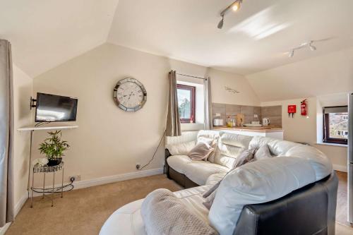 a living room with a white couch and a tv at Goldfinch cottage in Newton