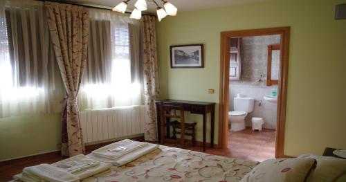 a bedroom with a bed and a bathroom with a toilet at Villa y Corte - Castillo in Ampudia