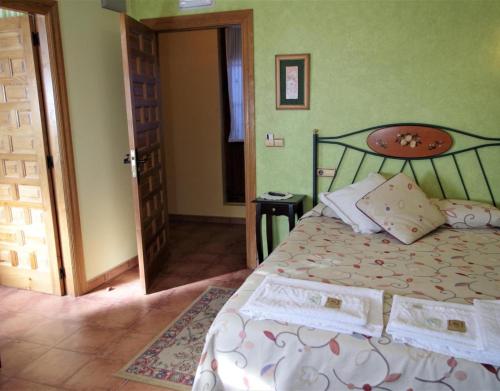 sypialnia z łóżkiem i otwartymi drzwiami w obiekcie Villa y Corte - Castillo w mieście Ampudia