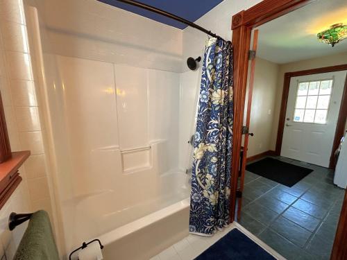 a bathroom with a tub with a shower curtain at Lady Mary Angeline in Saint Ignace