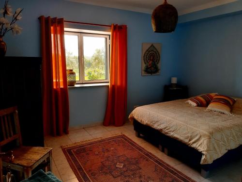 een slaapkamer met een bed en een raam met rode gordijnen bij Quinta da Barroca do Cabo in Ázere