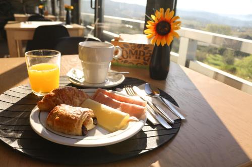 einen Teller mit Brot, Käse und Orangensaft in der Unterkunft Quinta da Seixeda in Alijó