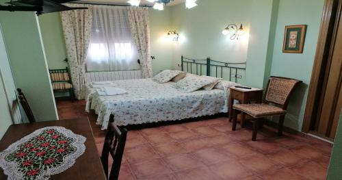 - une chambre avec un lit, une table et des chaises dans l'établissement Villa y Corte - Colegiata, à Ampudia