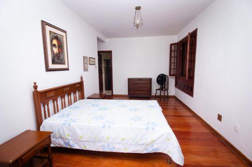 um quarto com uma cama e piso em madeira em Chacara totalmente equipada em Juiz de Fora MG em Juiz de Fora