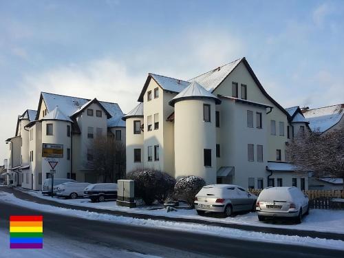 a row of houses with cars parked in a parking lot at Little Castle near Airport and Messe in Steinenbronn