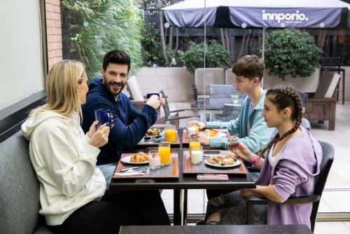 grupa ludzi siedzących przy stole jedzących jedzenie w obiekcie Holiday Inn Express Santiago Las Condes, an IHG Hotel w mieście Santiago