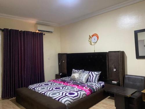 um quarto com uma cama e um relógio na parede em Light house em Lagos