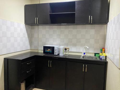 a kitchen counter with a sink and a microwave at Light house in Lagos
