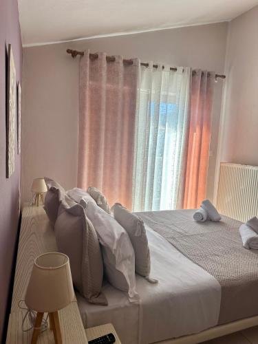 a bedroom with a bed with pillows and a window at Christina's Home in Skiathos Town