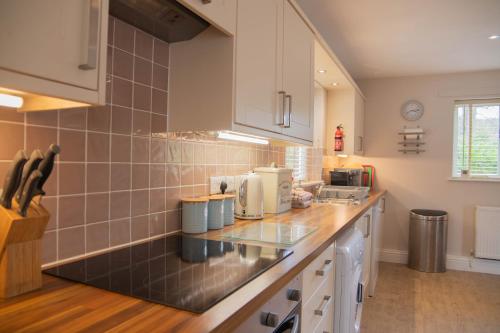 a kitchen with white cabinets and a counter top at Dale Cottage in Telford