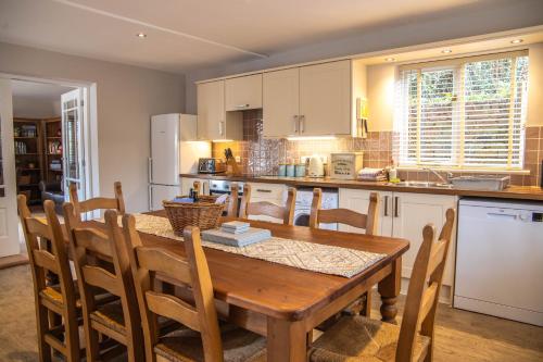 a kitchen with a wooden table and some chairs at Dale Cottage in Ironbridge