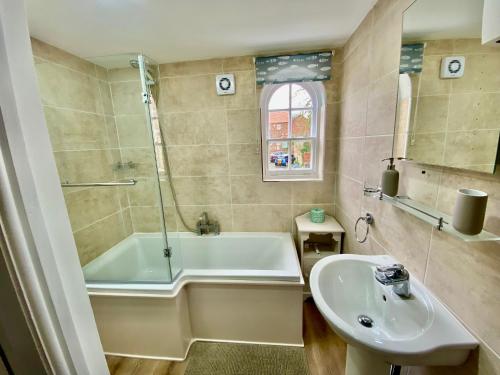 y baño con bañera y lavamanos. en Characterful 3 Bed cottage in Barrow upon Humber en Barrow upon Humber