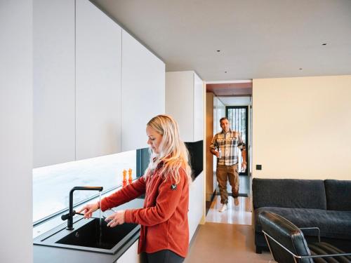 une femme debout dans la cuisine d'une maison dans l'établissement Grend Blefjell, à Svene