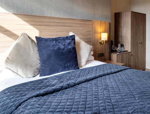 a bedroom with a large bed with blue sheets and pillows at The Seven Chester in Chester