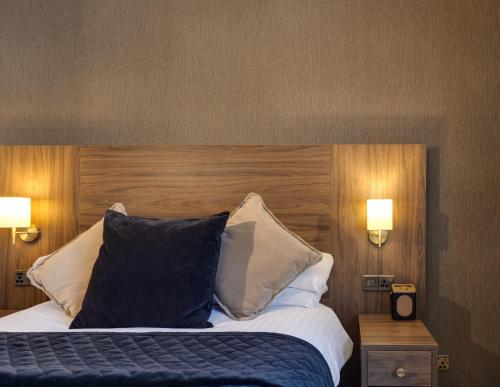 a bedroom with a large bed with a wooden headboard at The Seven Chester in Chester