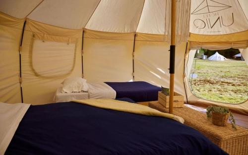 een slaapkamer met 2 bedden in een tent bij Hôtel UNIQ - Domaine Saint-Bernard in Mont-Tremblant