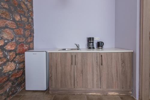 a kitchen with a sink and a refrigerator at GIN Wellness Hotel in Pyrgos