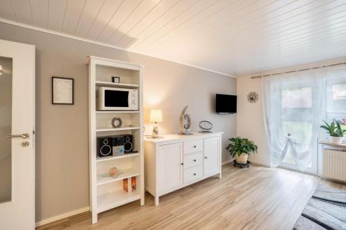 a living room with a white cabinet and a microwave at Ferienwohnung Odenwald in Wald-Michelbach