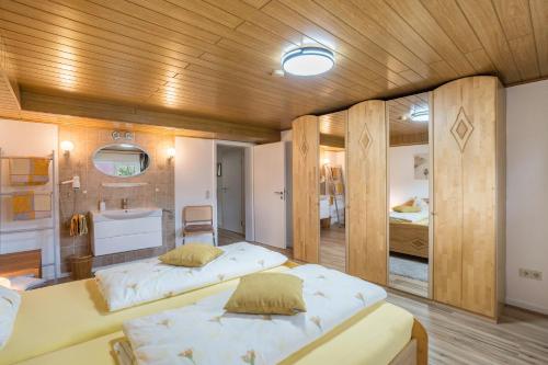 two beds in a room with a bathroom at Ferienwohnung Odenwald in Wald-Michelbach