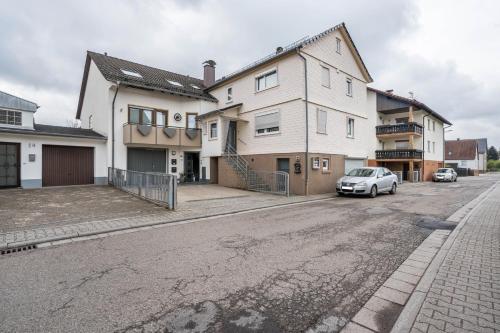a house with a car parked in front of a street at Ferienwohnung Odenwald in Wald-Michelbach