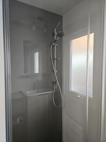 une salle de bain avec douche et lavabo dans l'établissement Kokua Vacances présente MOBIL HOME résidentiel toutes options camping 4 étoiles CANET, à Canet