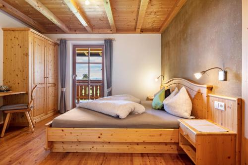 a bedroom with a wooden bed and a window at Ronsolhof Santner in Siusi