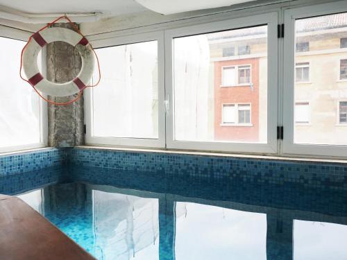 a swimming pool with a mirror and windows at B & B Da Lella in Trieste