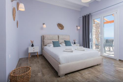 a white bedroom with a bed and a balcony at GIN Wellness Hotel in Pirgos