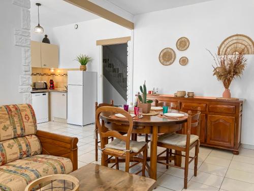 Una cocina y una sala de estar con mesa y sillas. en Evasion Côtière Oléron, en Bourcefranc