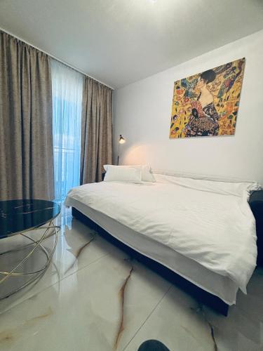 a bedroom with a large white bed and a window at Golden Apartament in Şelimbăr