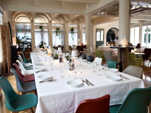 einen langen Tisch in einem Zimmer mit Tischen und Stühlen in der Unterkunft Ostella Spa & Resort in Bastia