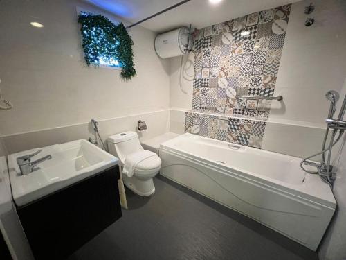 a bathroom with a tub and a toilet and a sink at Smile Hotel Shah Alam ICity in Shah Alam