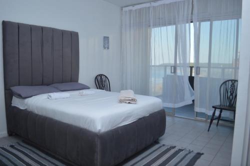 a bedroom with a large bed and a large window at Sea view short stay home in Durban