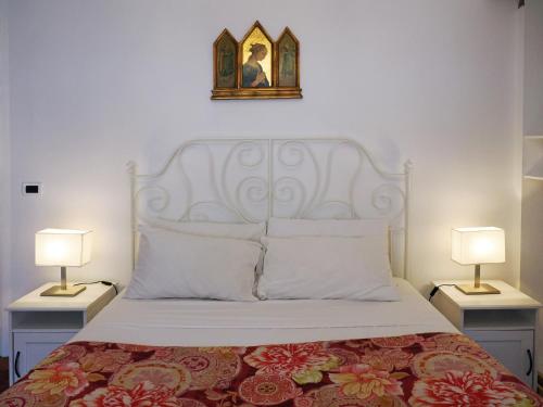 a bedroom with a bed with two lamps and a picture on the wall at B & B Da Lella in Trieste