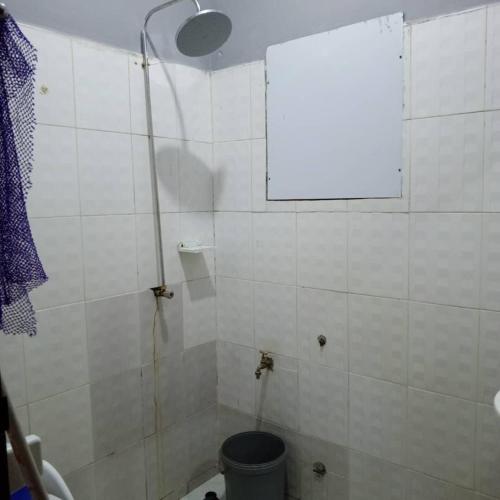 a bathroom with a shower with a toilet and a window at Appartement 2 Chambre Salon à Abomey-Calavi Bakita in Abomey-Calavi