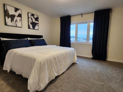 een slaapkamer met een groot bed en een groot raam bij Exclusive Home in Niagara Falls in Thorold