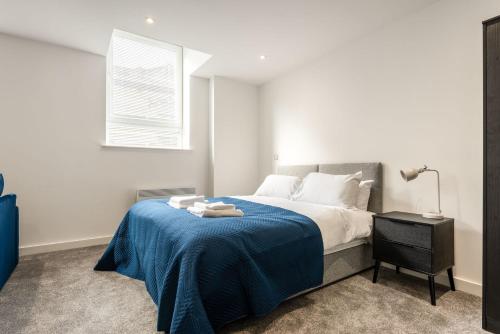 a bedroom with a bed with a blue blanket at Contemporary Studio Apartment in Central Rotherham in Rotherham