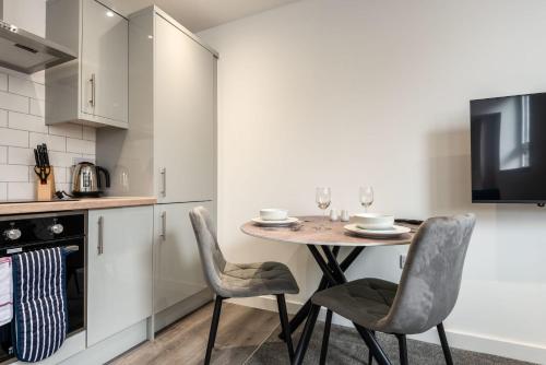 a kitchen with a table and chairs in a room at Contemporary Studio Apartment in Central Rotherham in Rotherham