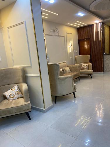 a waiting room with couches and chairs in a building at Explore Stars Pyramids View in Cairo