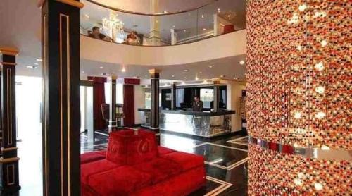 a living room with a red couch and a wall at Five Star Nile Cruise from Aswan to Luxor in Aswan
